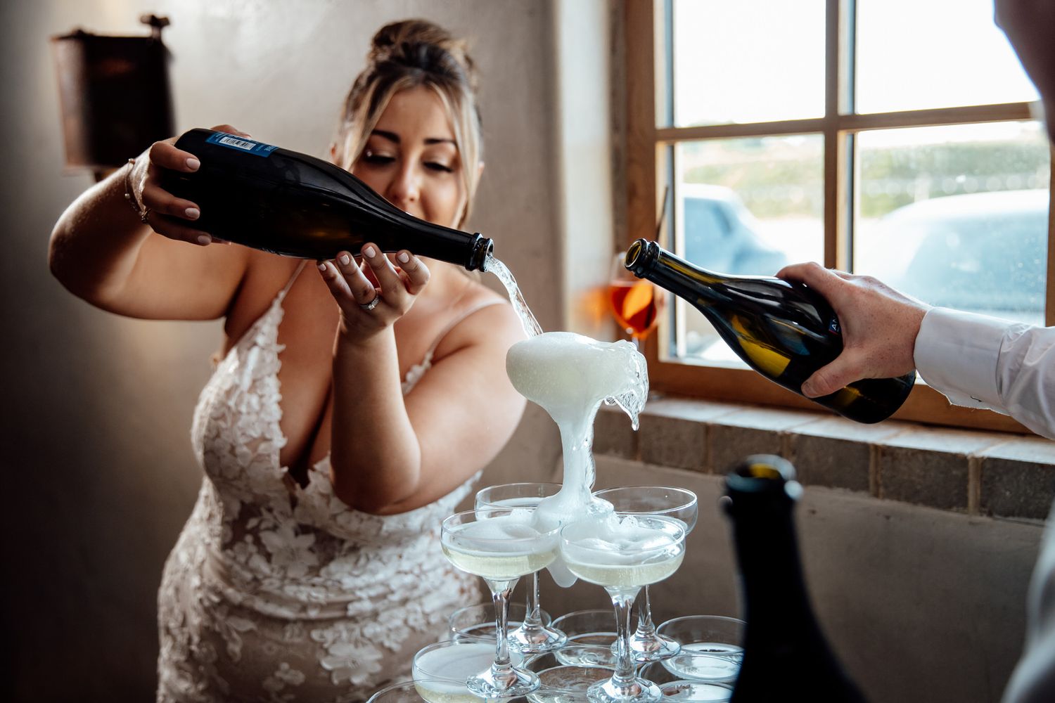 Champagne being poured into elegant glasses during wedding reception.