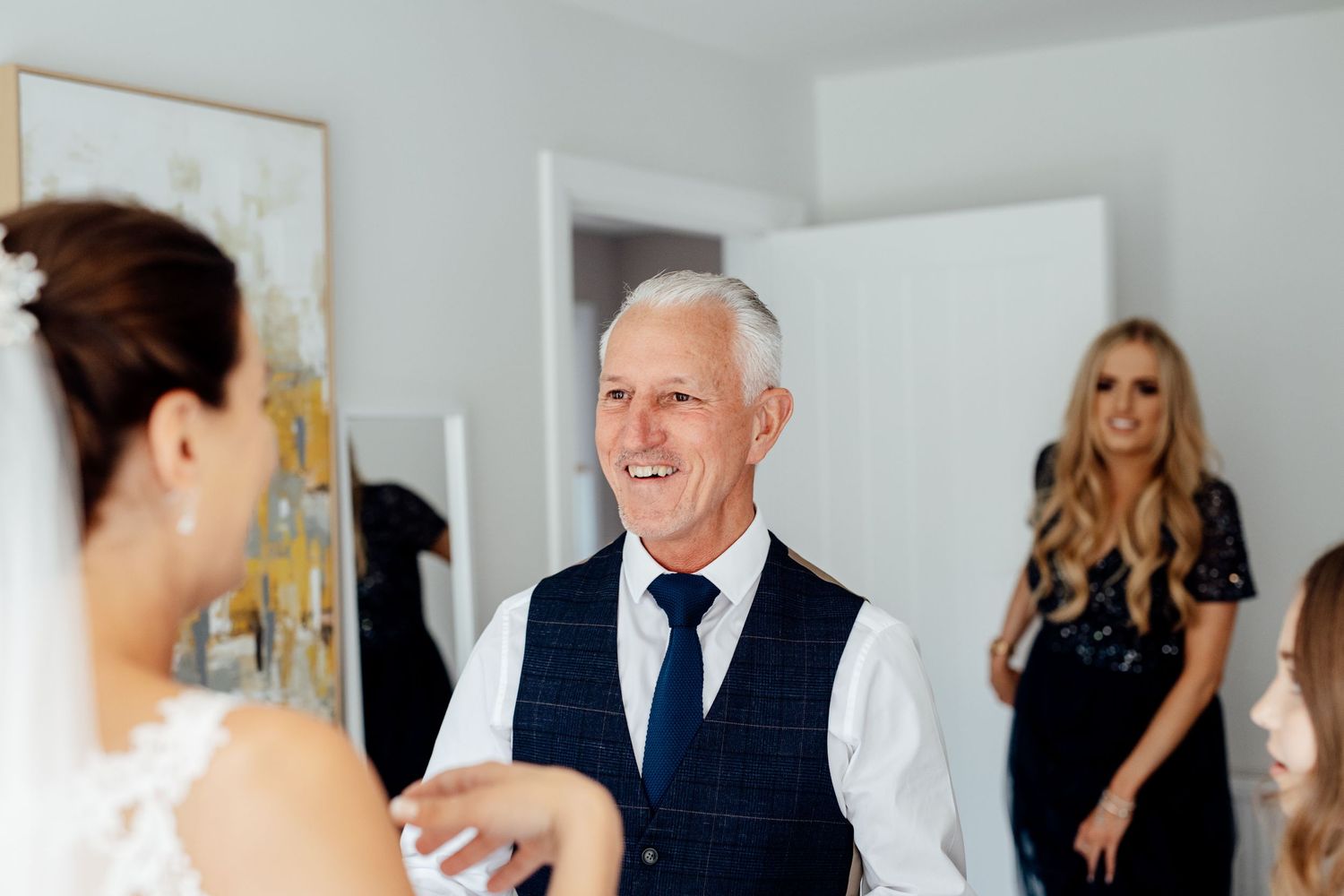 An emotional moment captured during wedding preparations in a bright indoor setting.