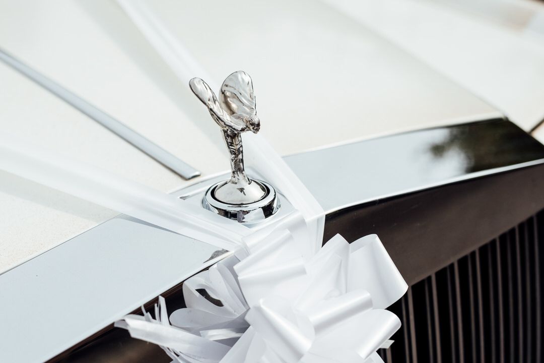 Classic Rolls-Royce Spirit of Ecstasy hood ornament in silver against white background.