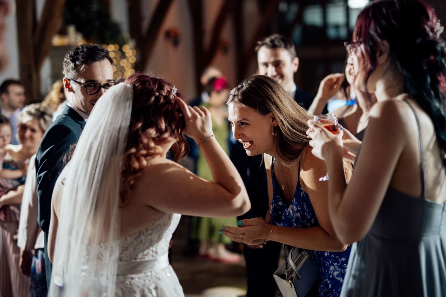 Wedding reception dance floor filled with guests enjoying celebratory moments.