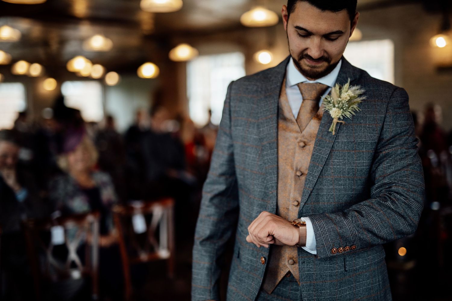 A couple shares a joyful dance moment at their wedding reception under warm lighting.