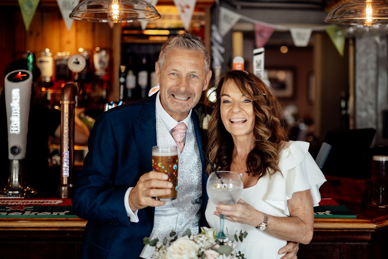 Couple enjoying drinks together at rustic pub with warm ambient lighting.
