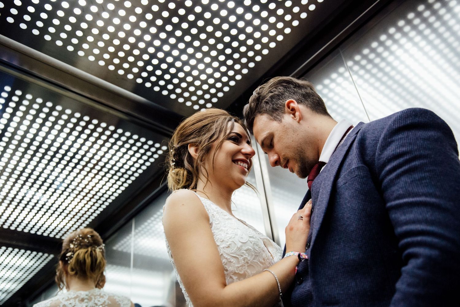Couple sharing a close dance moment under modern ceiling lighting.