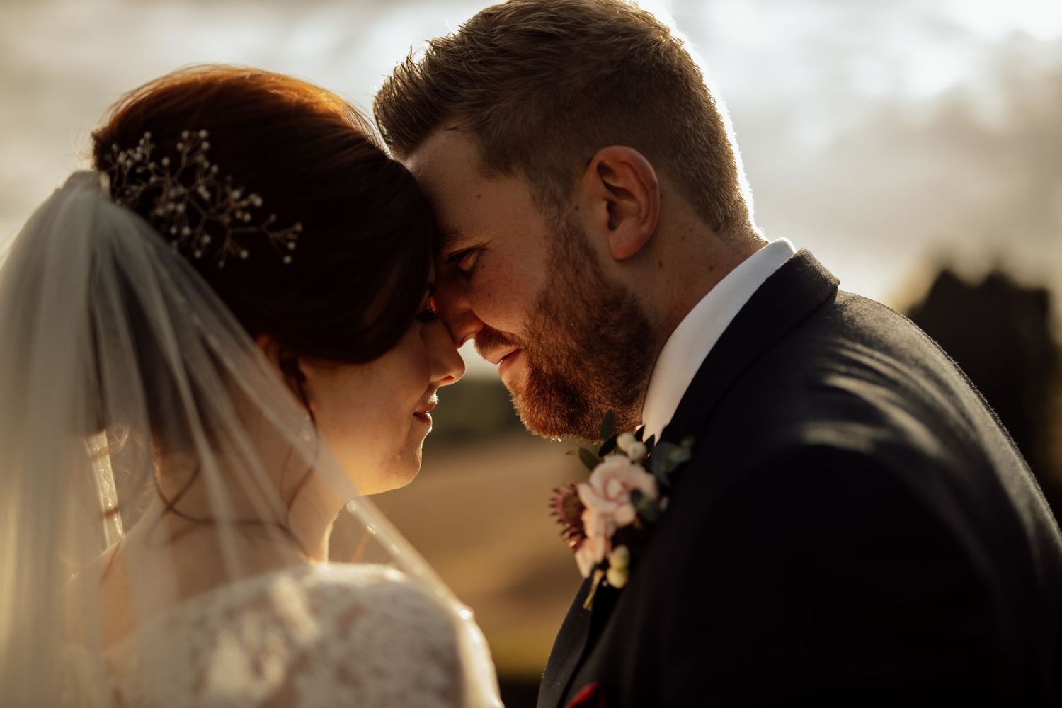 Intimate silhouettes of a wedding couple during golden hour create a romantic backlit portrait.