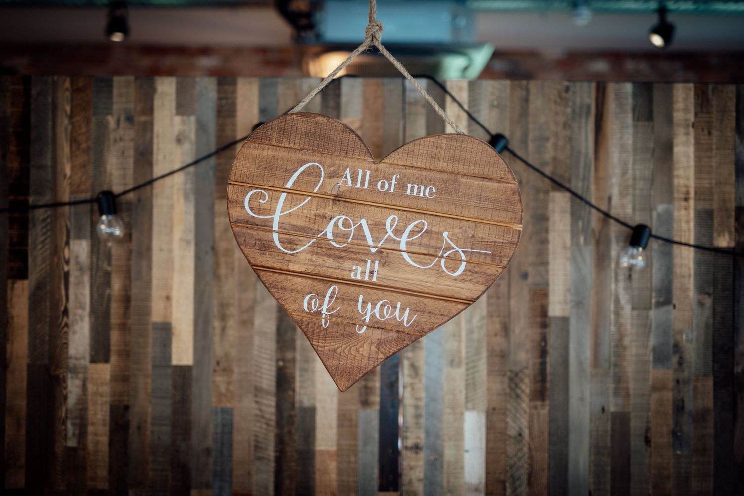 Rustic wooden signs with romantic messages displayed on a weathered wall.