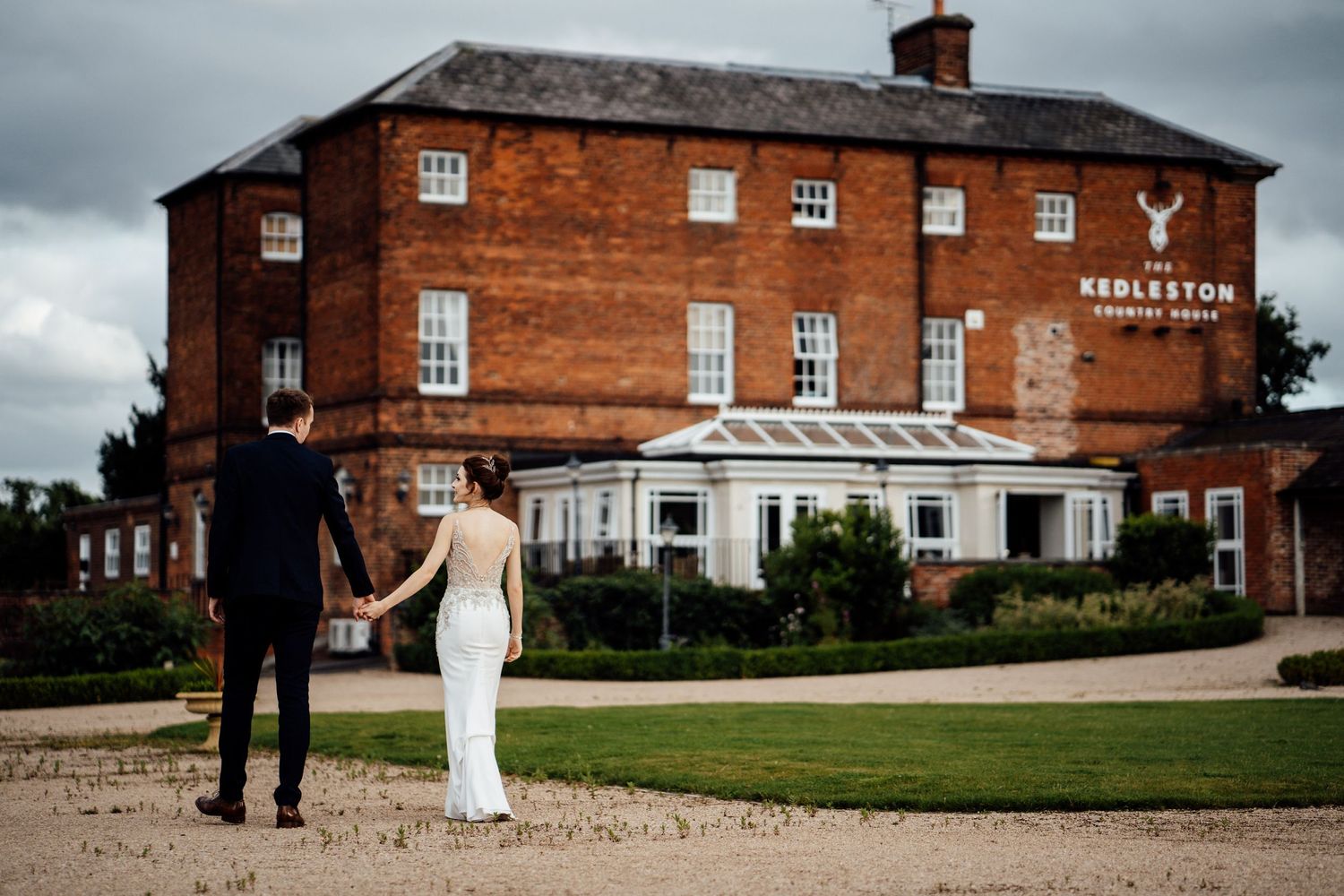 Panoramic view of historic brick wedding venue with manicured grounds.