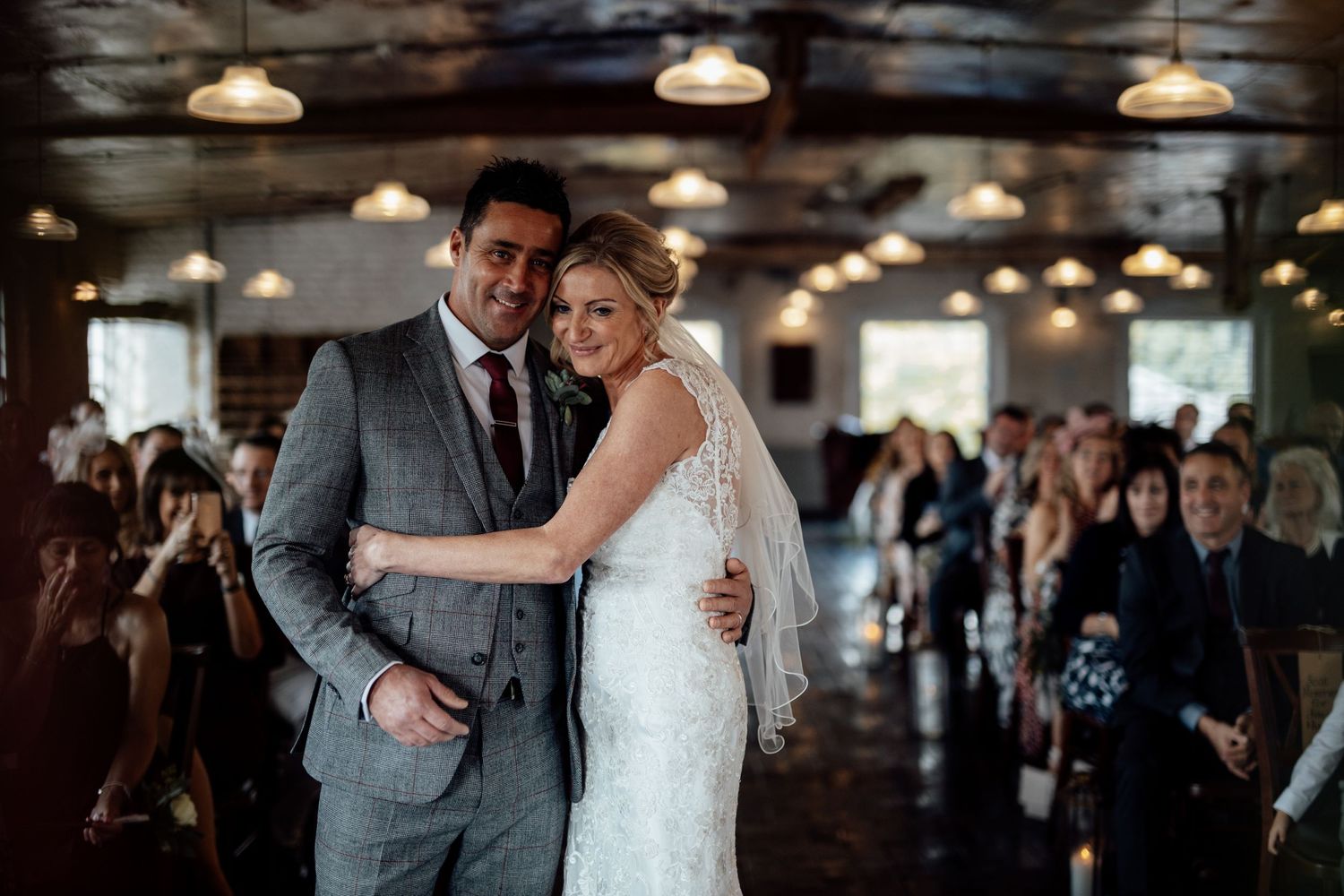 Couple sharing intimate moment during first dance at industrial-style wedding venue.