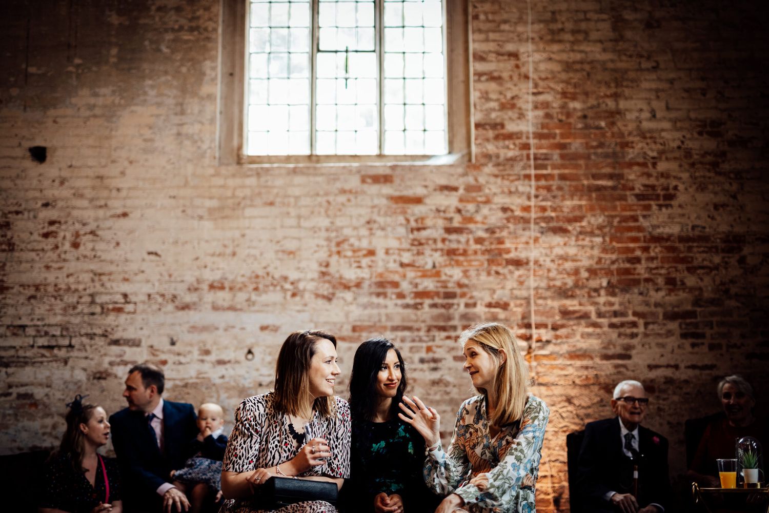 Interior of rustic brick venue with exposed walls and windows.