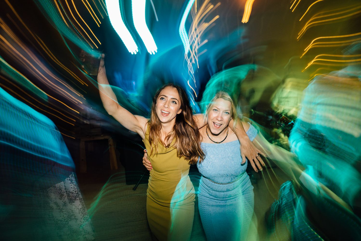 Dynamic party scene with colorful light trails and motion blur in a tipi venue.