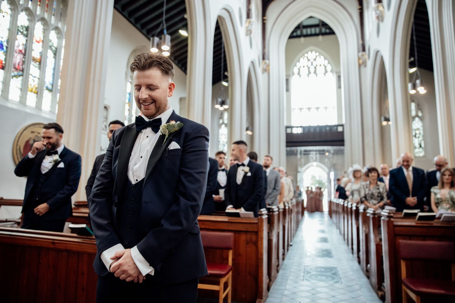 Elegant church interior with long aisle, arched windows, and gothic architectural details.