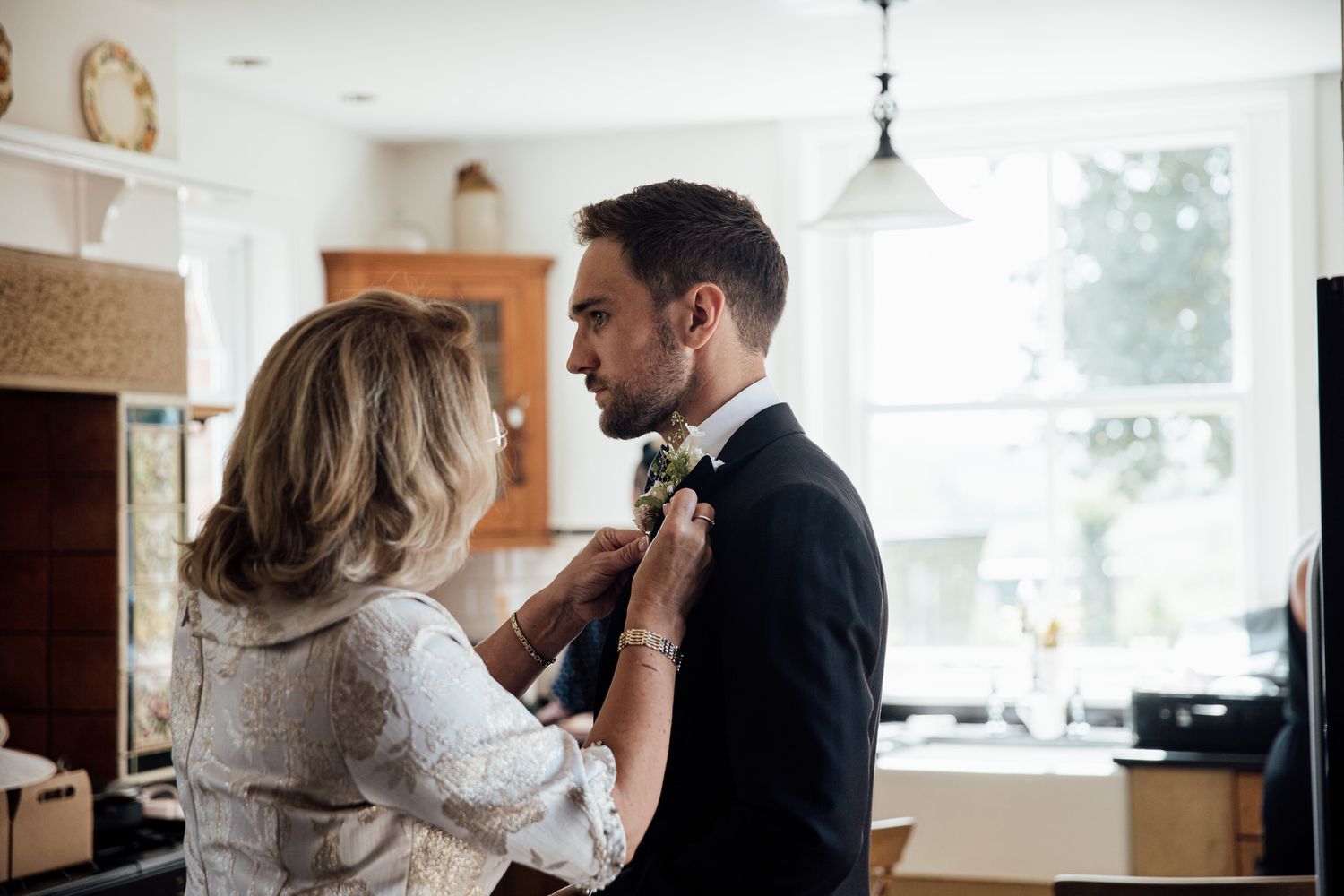 Intimate indoor wedding preparation moments captured in bright natural light.