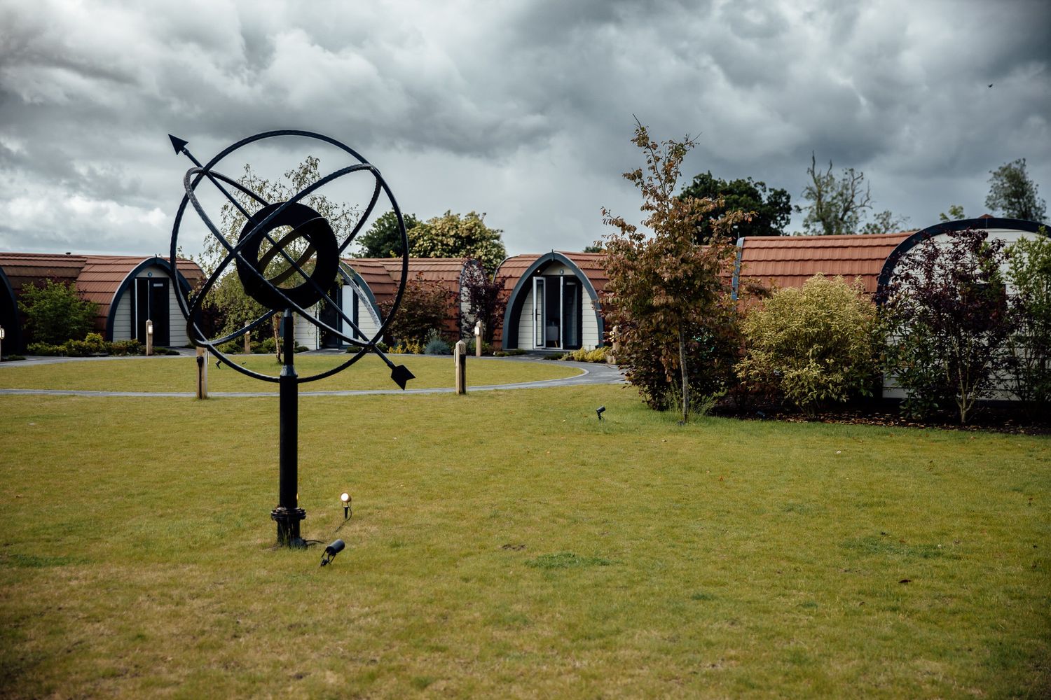 Dramatic cloudy sky over outdoor wedding venue with metal art installations.