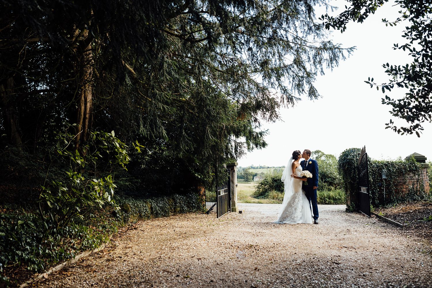 Tree-lined gravel path leading to a scenic wedding location.