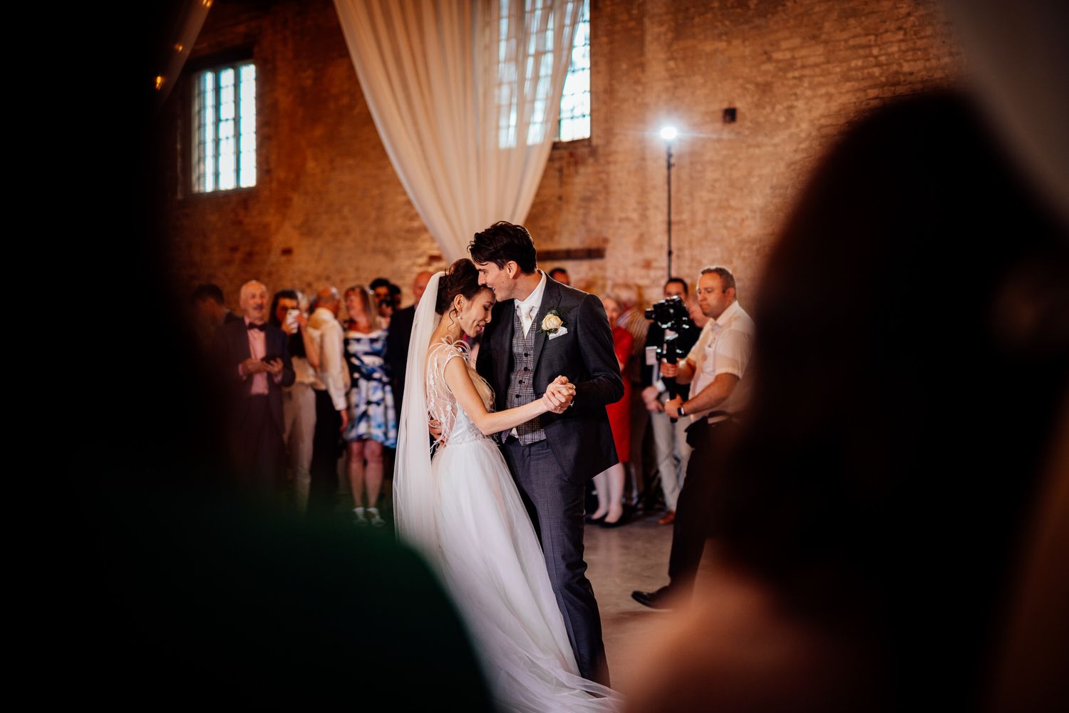 Wedding celebration in a rustic brick venue with soft lighting and romantic atmosphere.