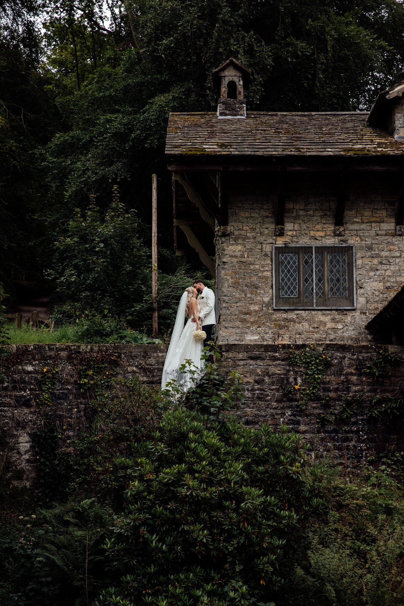Stone chapel exterior with rustic architecture and surrounding greenery creates a romantic wedding backdrop.