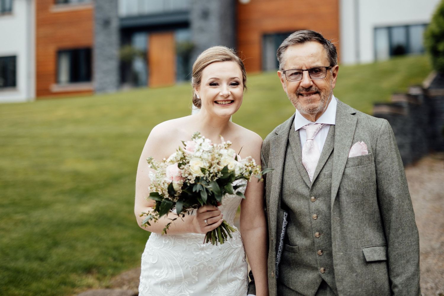 A joyful wedding celebration outside a brick building with guests in formal attire.