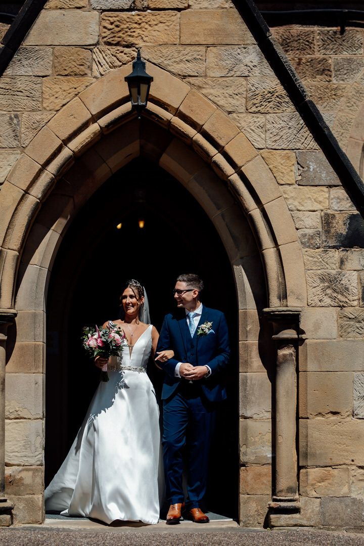 A series of stone archway frames showing a couple in wedding attire walking through a historic church entrance.
