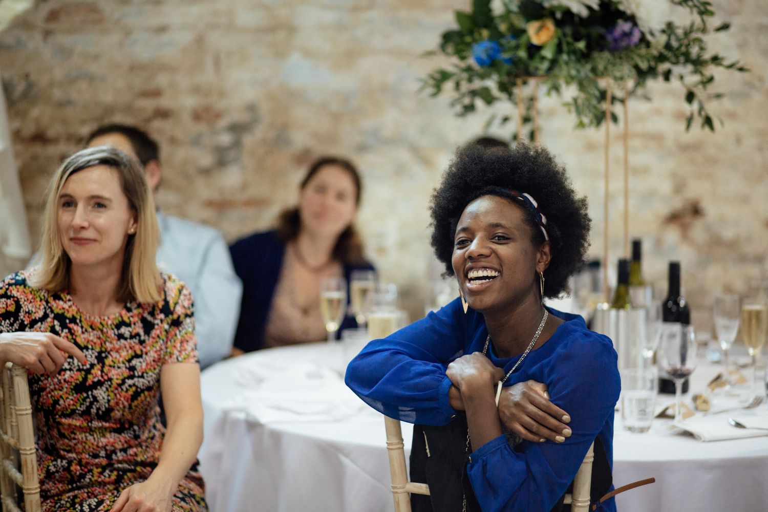 Wedding reception guests enjoying conversation at decorated table.