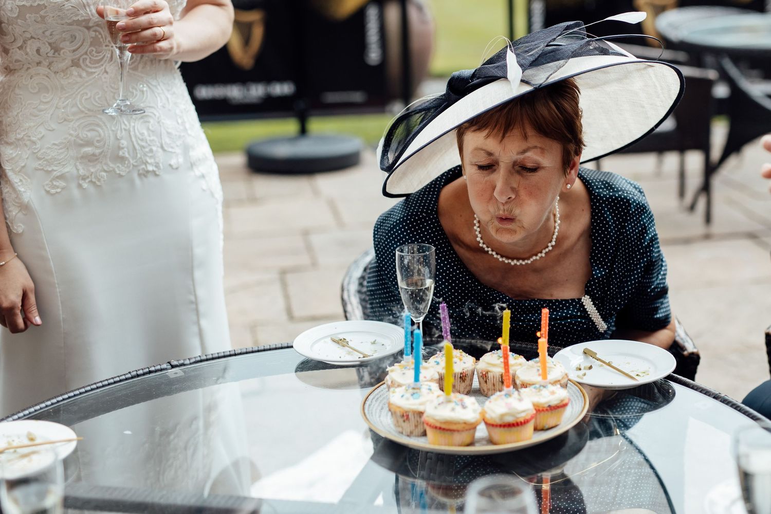 Wedding guests enjoying cake and refreshments at outdoor reception.