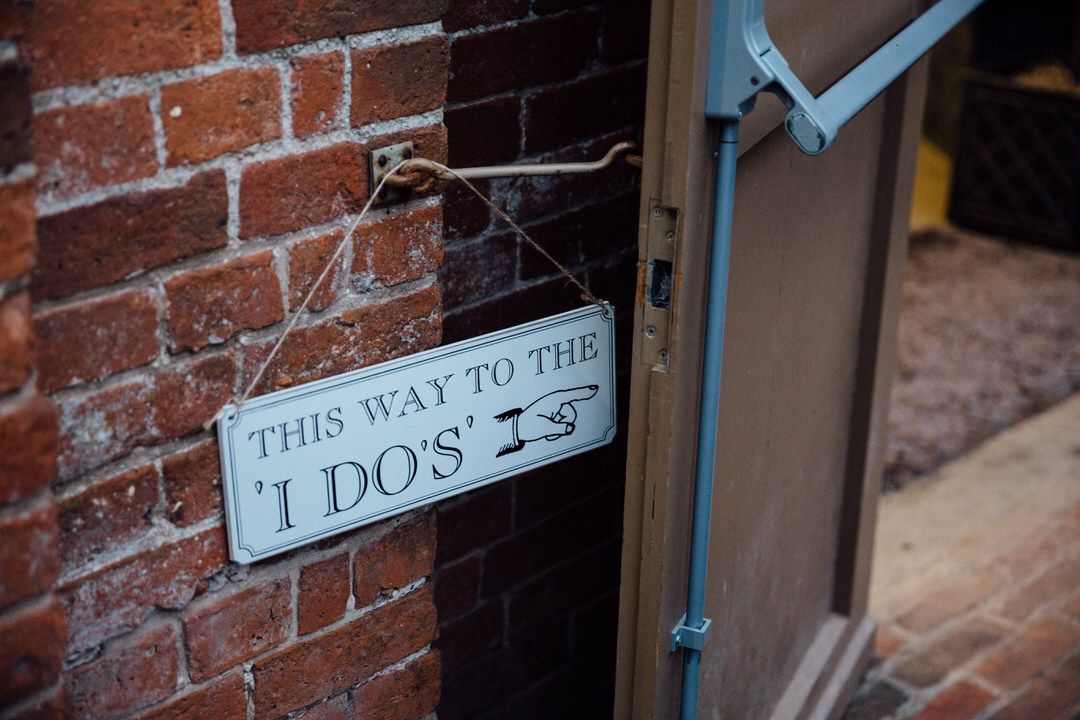 Vintage style directional signs mounted on rustic brick wall.