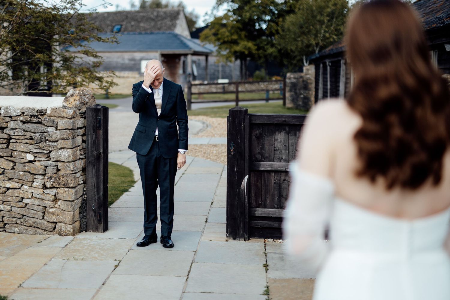 Wedding ceremony first look moment outside rustic stone building.