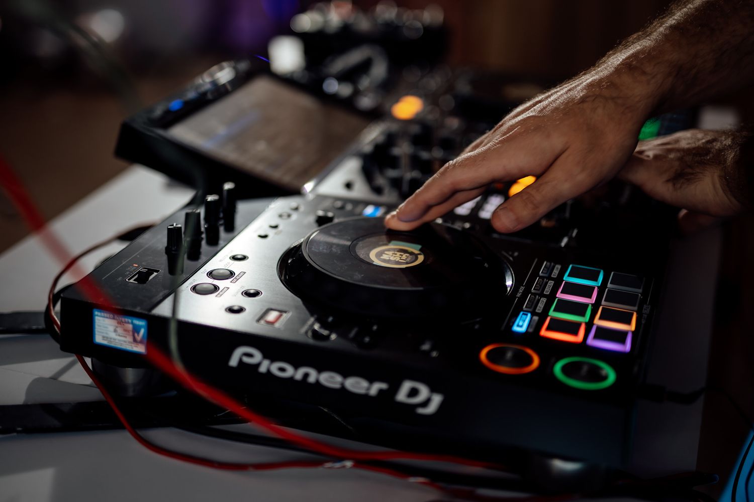 Close-up of DJ equipment and controllers at wedding reception.