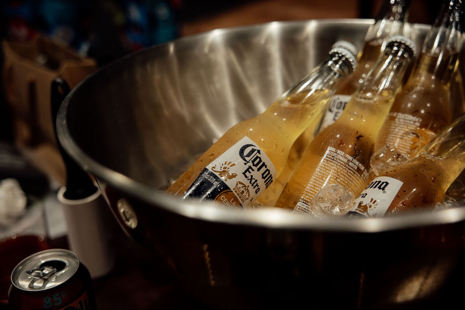 Corona beer bottles chilling in ice-filled metal bucket at wedding reception bar.