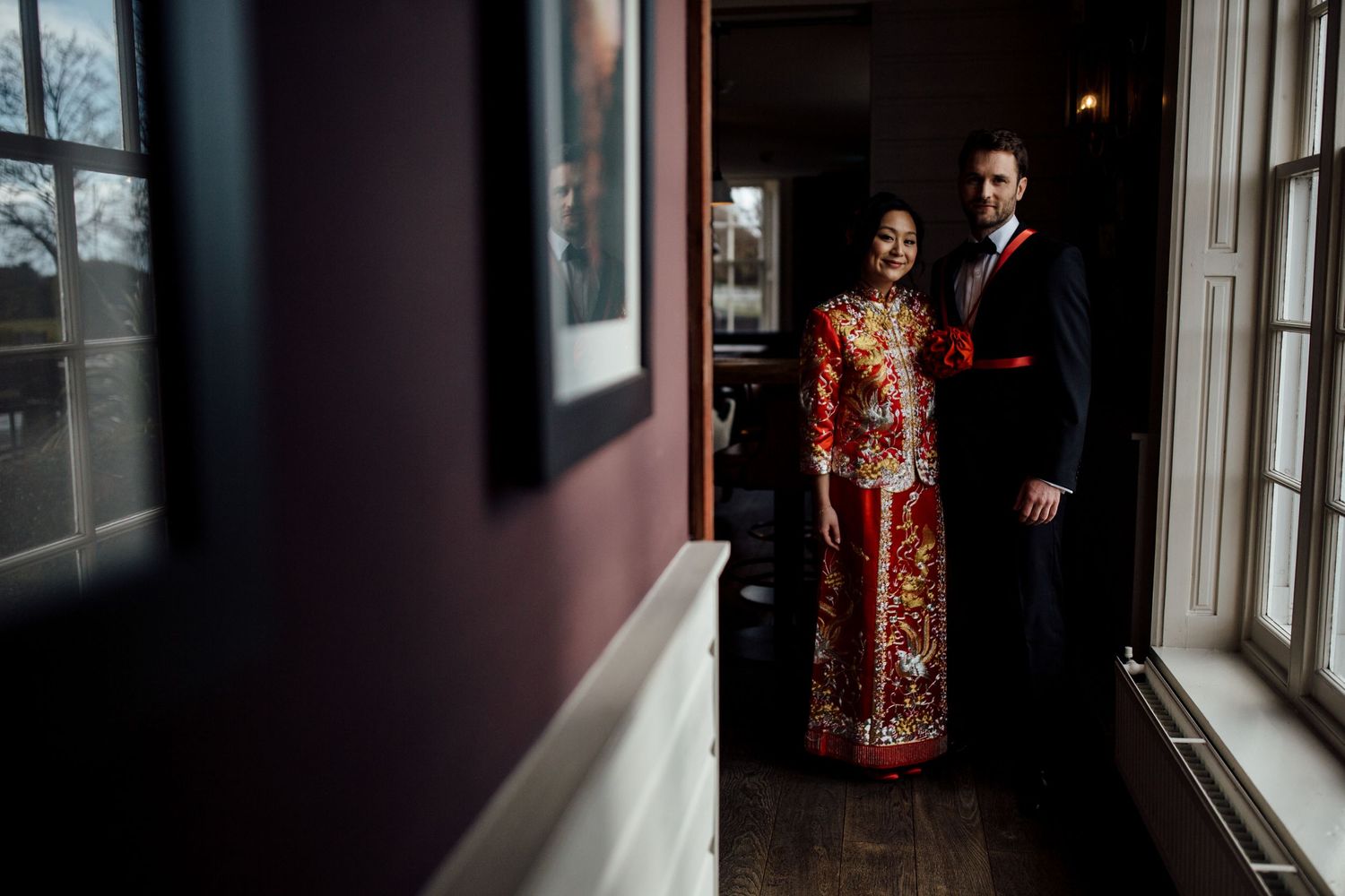 Dark moody hallway with window light streaming in during formal gathering.