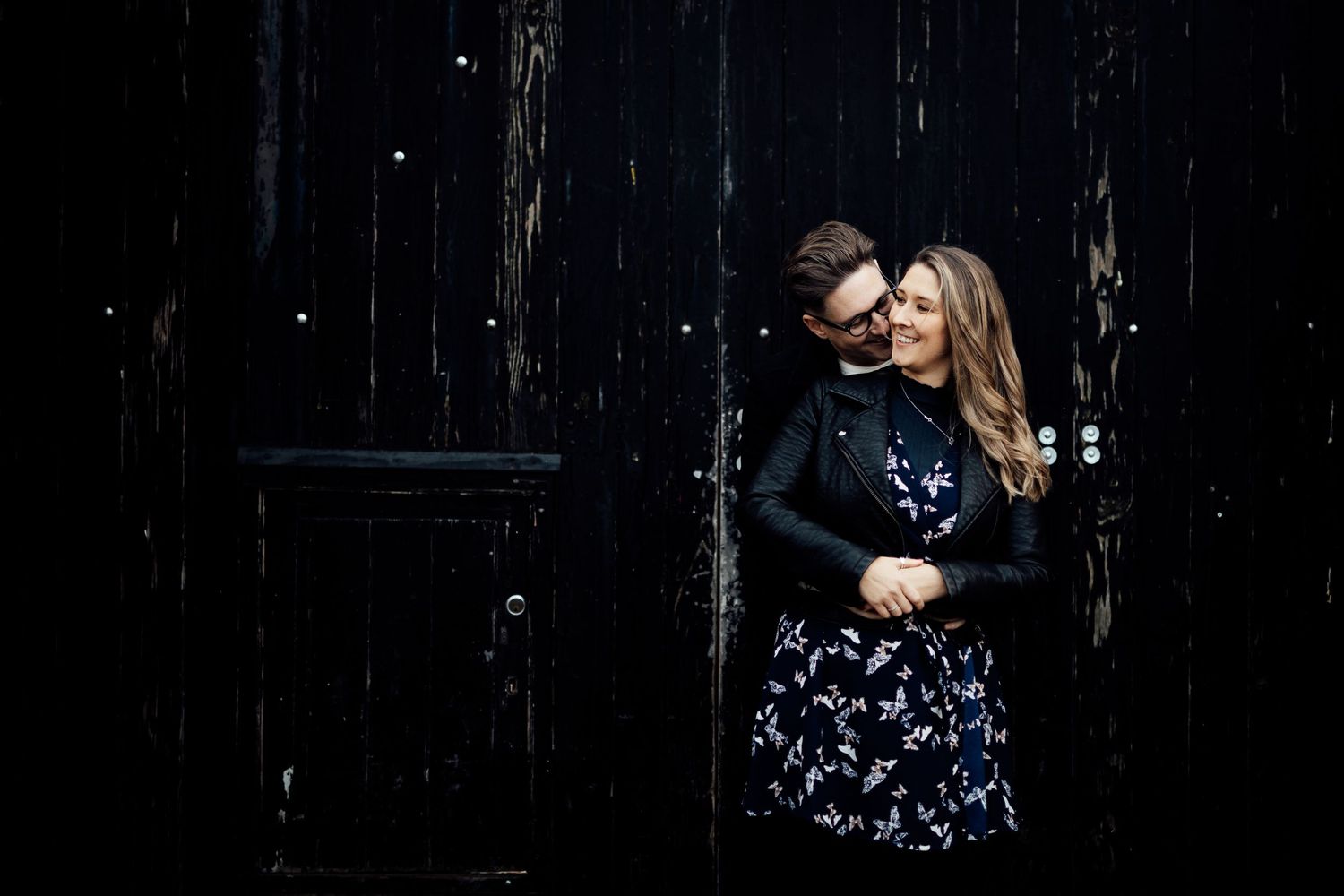 A romantic couple shares tender moments in a dimly lit setting.