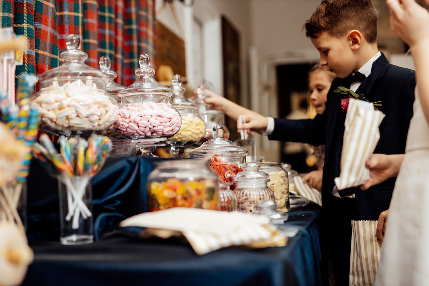 Wedding reception candy bar with glass jars of sweets and treats.