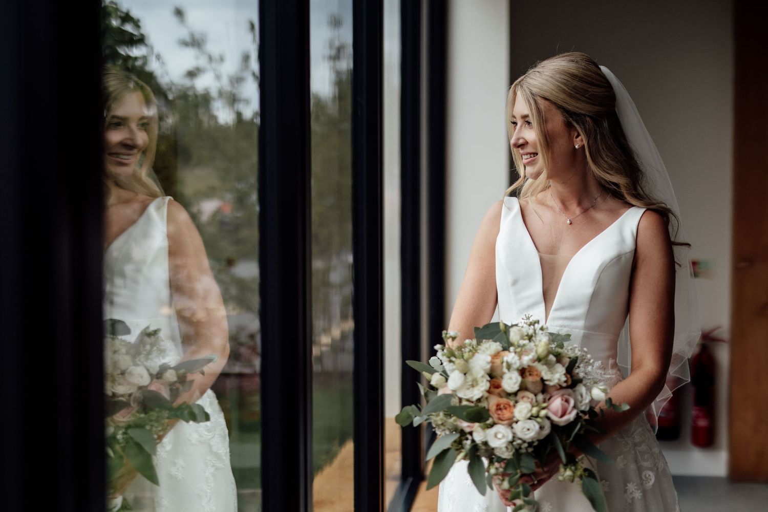 Bridal preparation moments captured through window reflections.