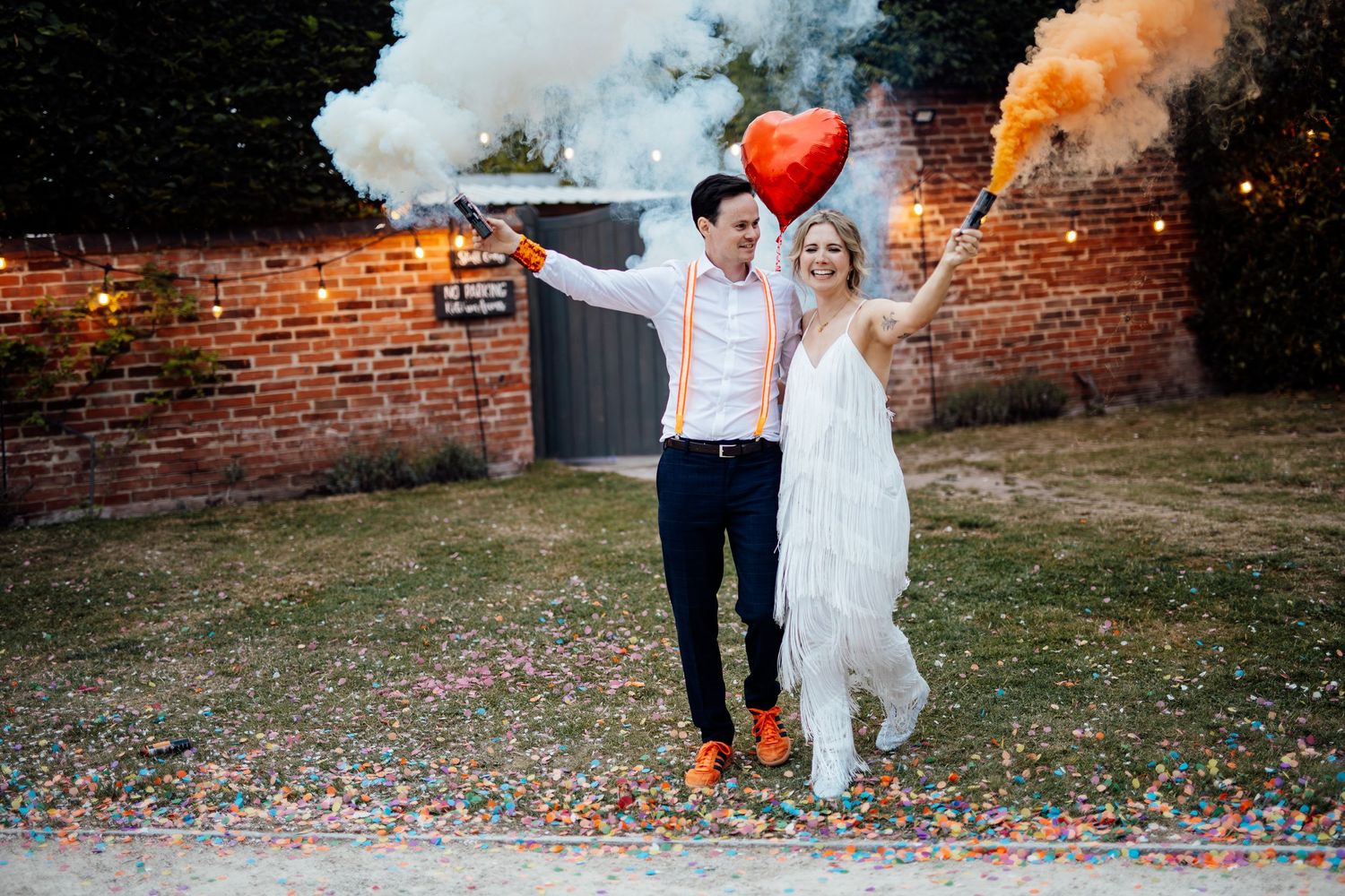 Colorful smoke bombs create dramatic effects at an outdoor wedding celebration.