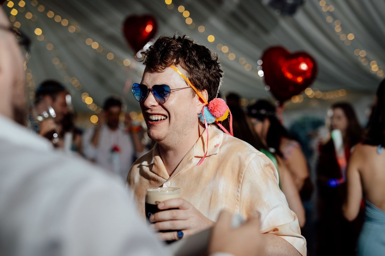 Wedding celebration with bokeh lights and festive atmosphere in background.