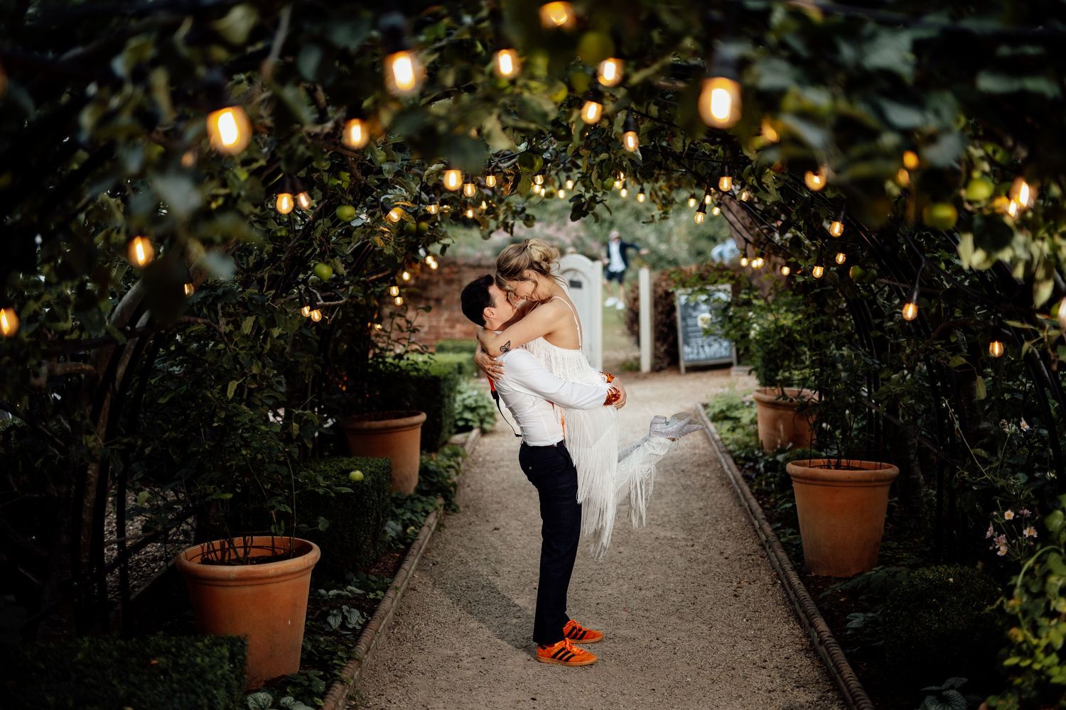 String lights illuminate a garden path creating magical wedding atmosphere.