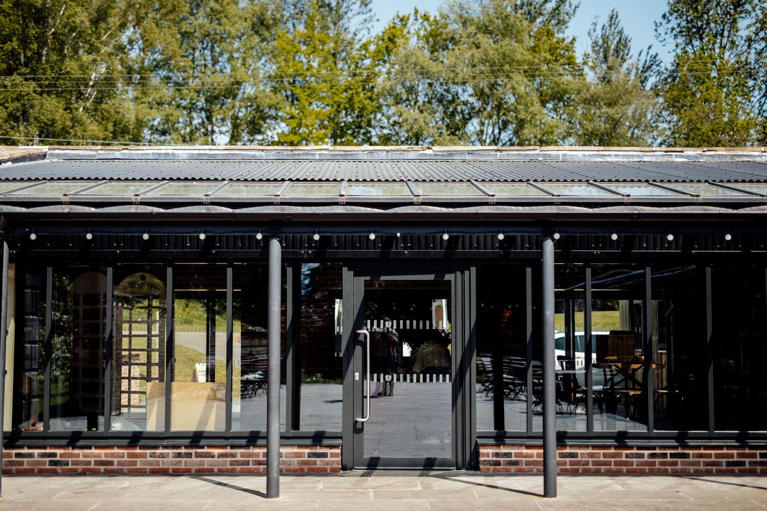 Modern event venue exterior with string lights and architectural details.