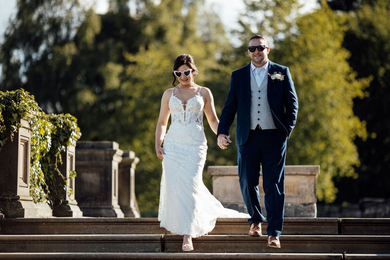 Elegant outdoor wedding photos taken on stone steps with greenery in background.