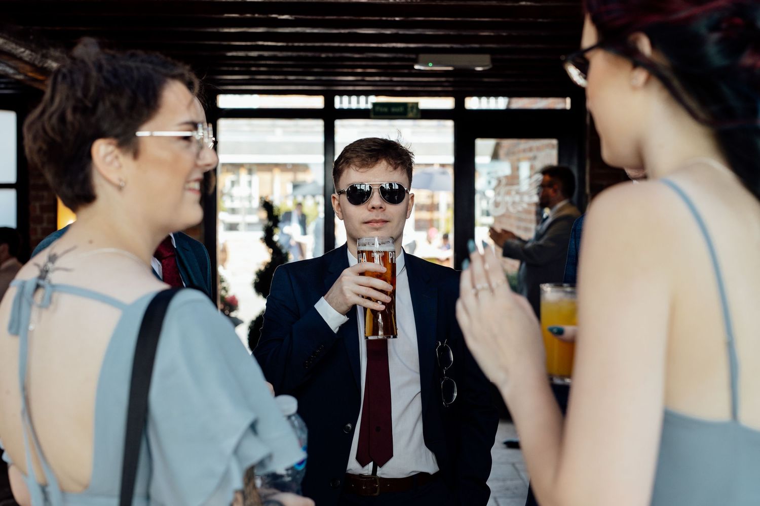 Wedding guests chatting and enjoying drinks at an indoor celebration.
