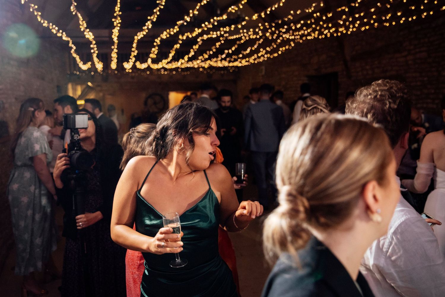 Wedding reception venue with twinkle lights strung across rustic brick ceiling.