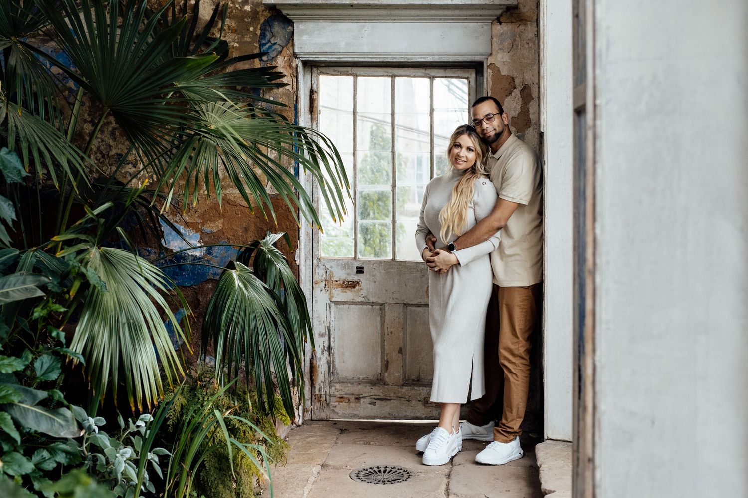 A romantic moment captured in an industrial space with tropical plants and natural light.