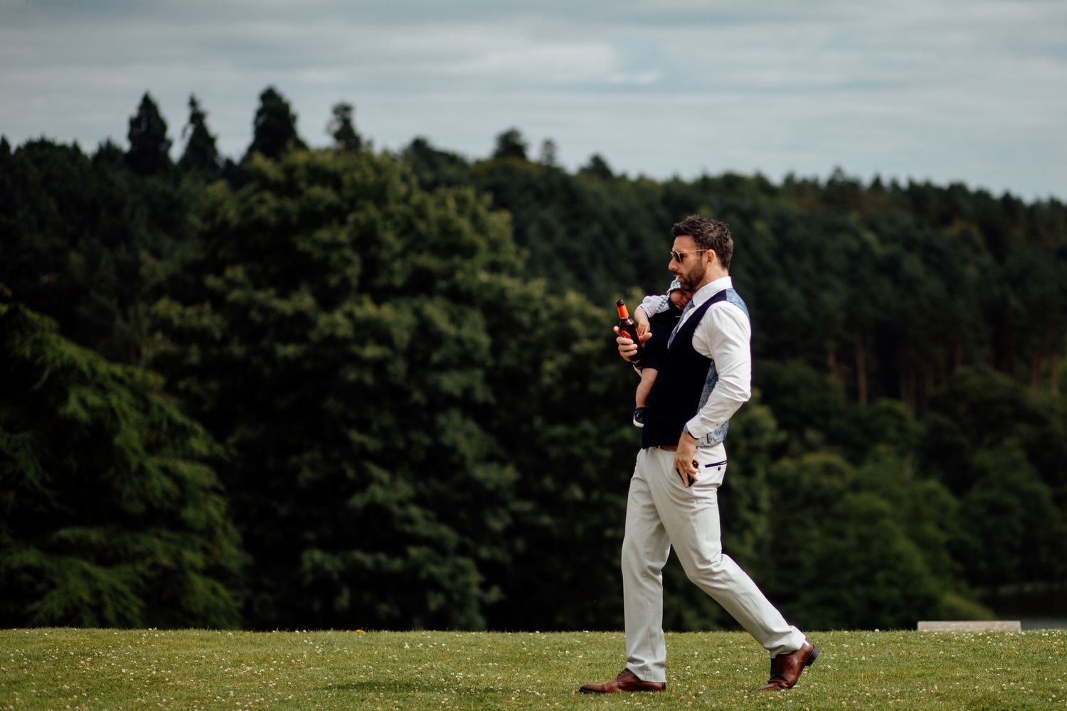 Wedding party members playing cricket on a green field.