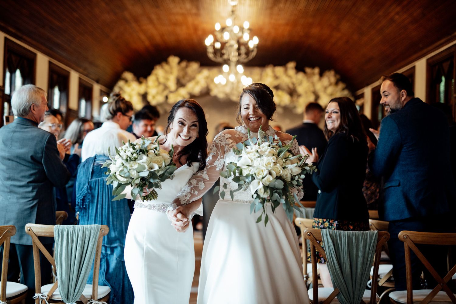 Elegant wedding reception venue with chandelier lighting and white floral decorations.