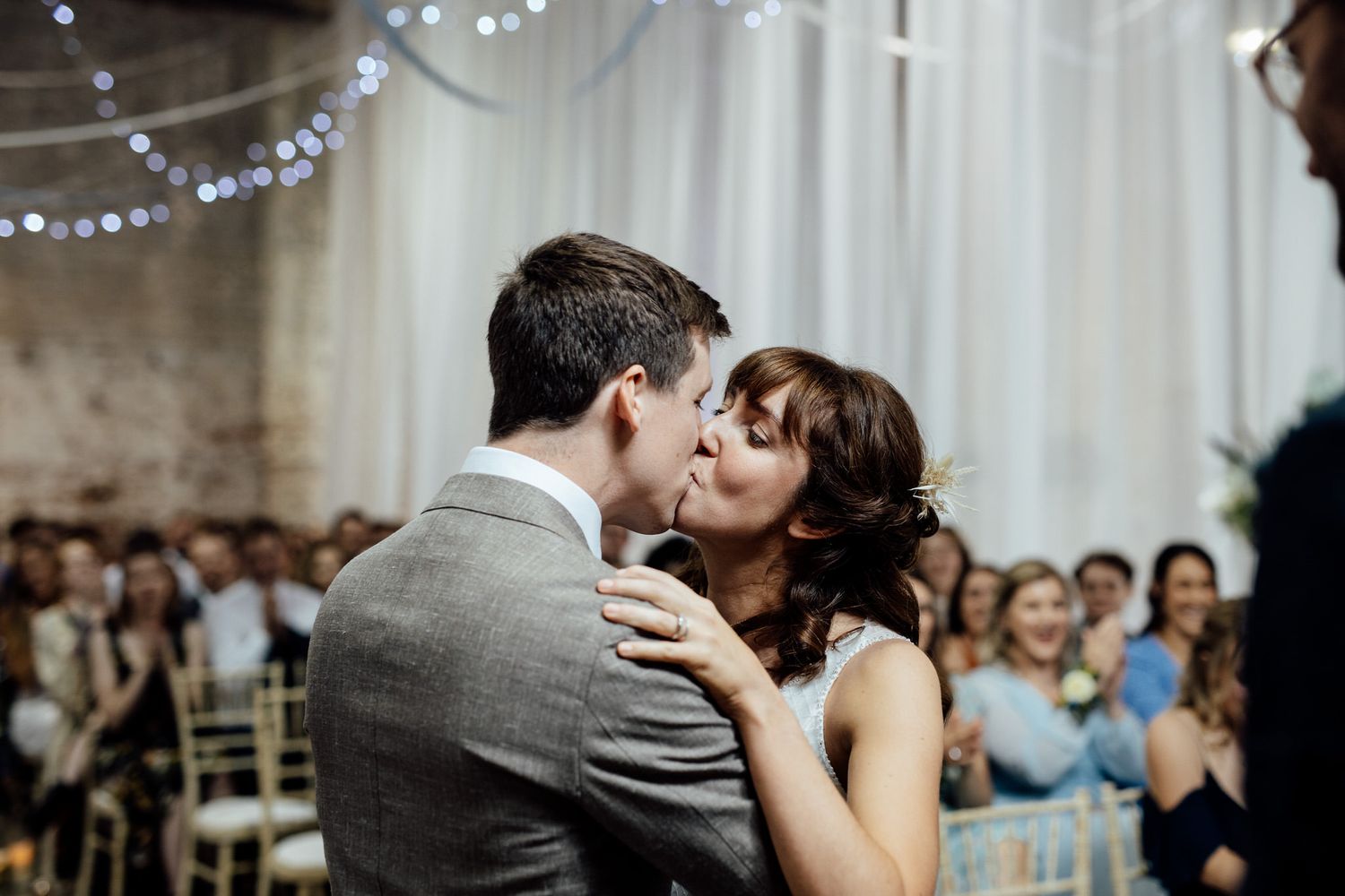 Wedding reception dance floor filled with guests under twinkling string lights.