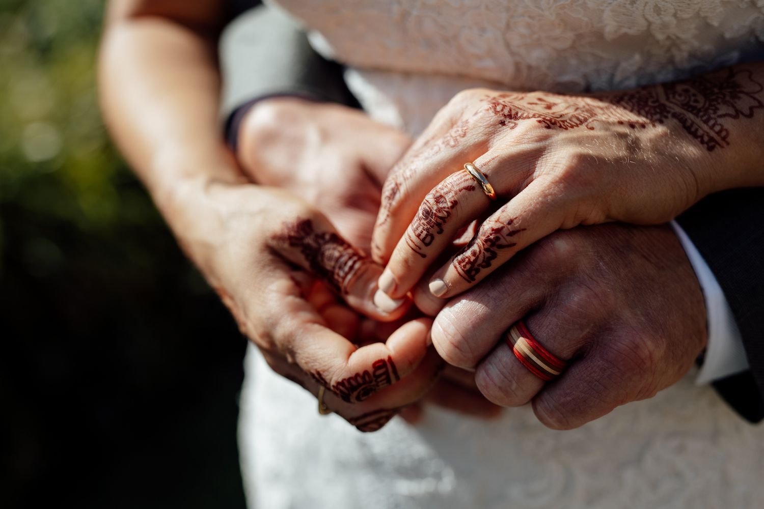 Close-up of hands exchanging wedding rings during ceremony.