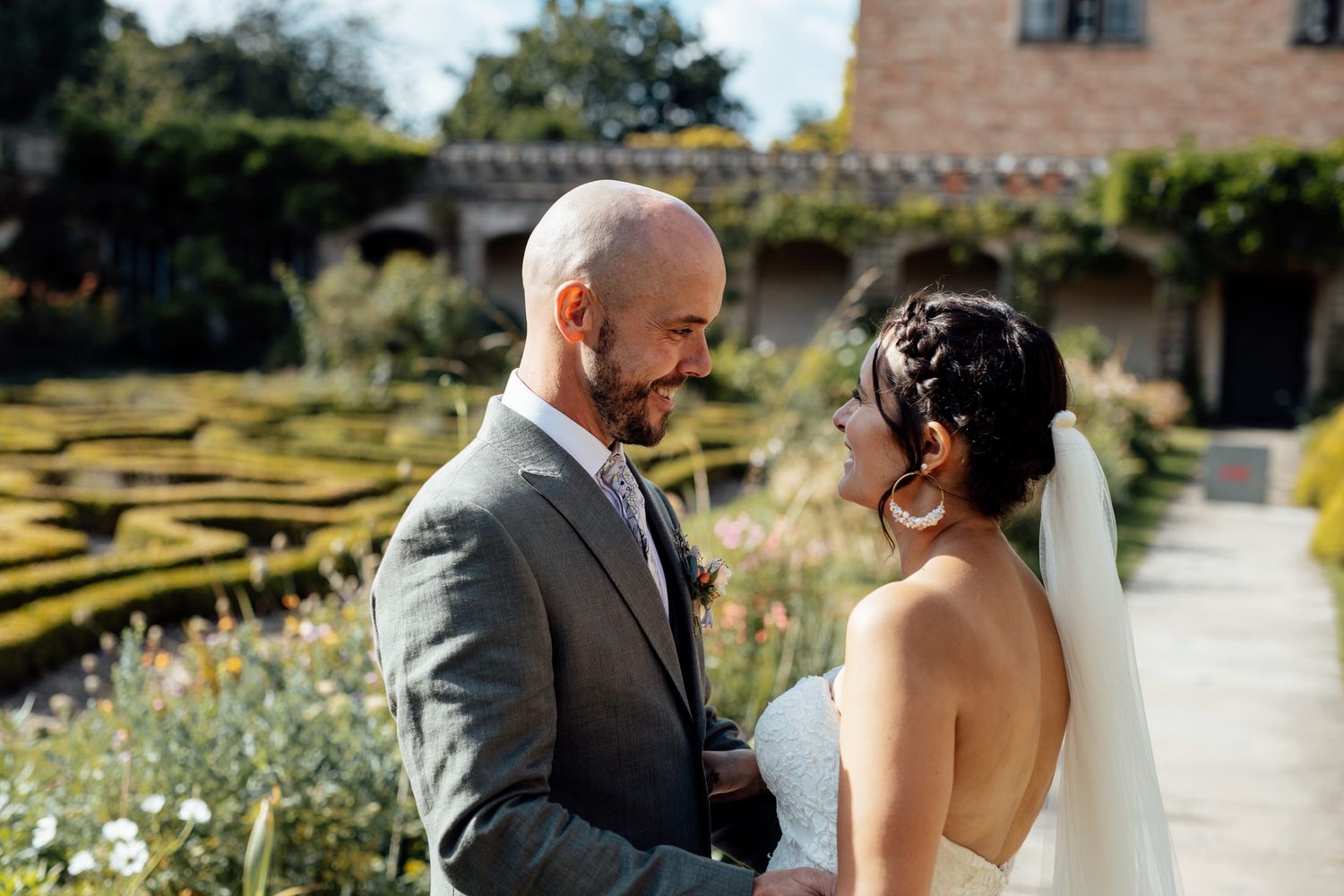 Wedding couple shares romantic moments in front of a rustic stone building.