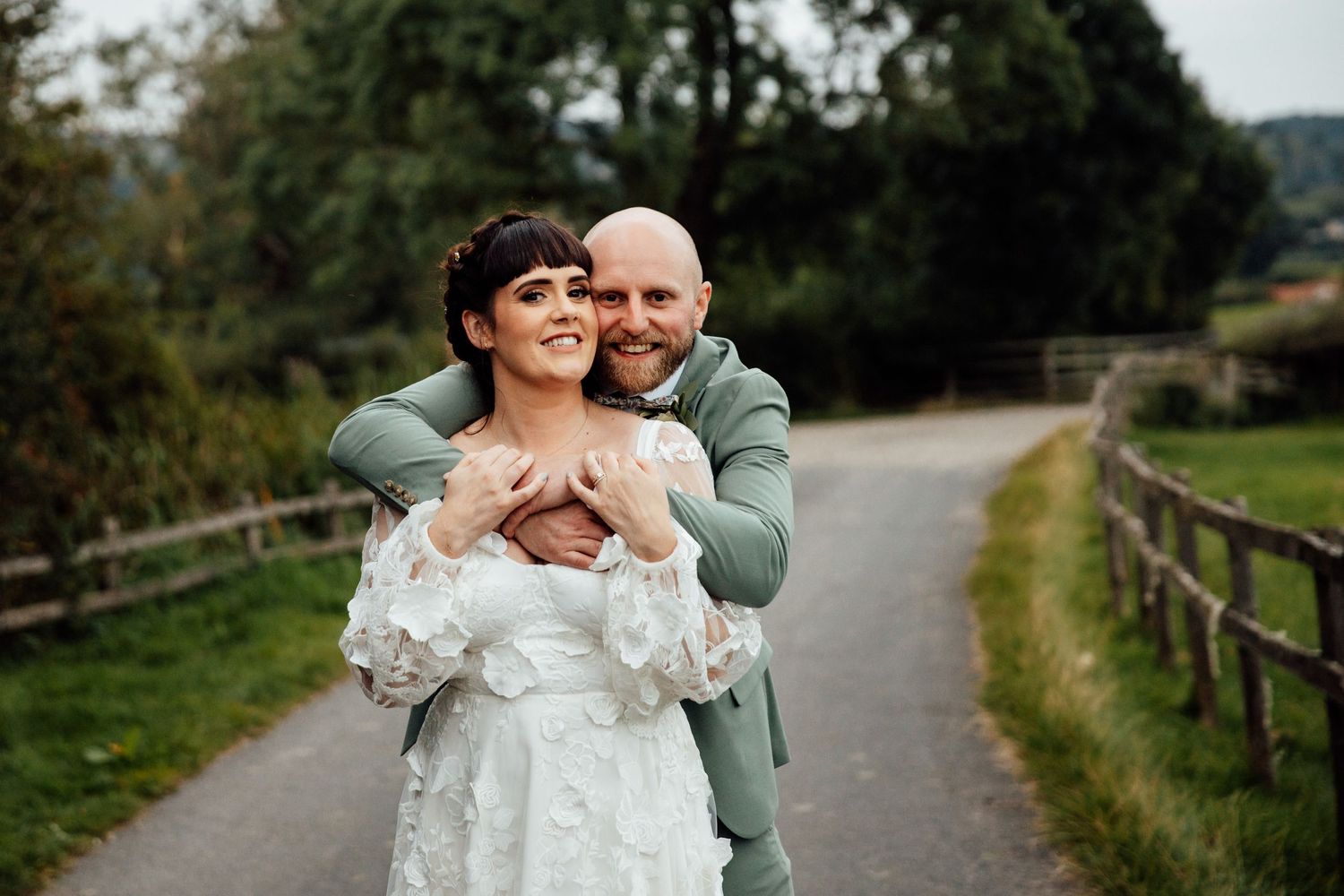 Romantic outdoor wedding portraits along a countryside path.