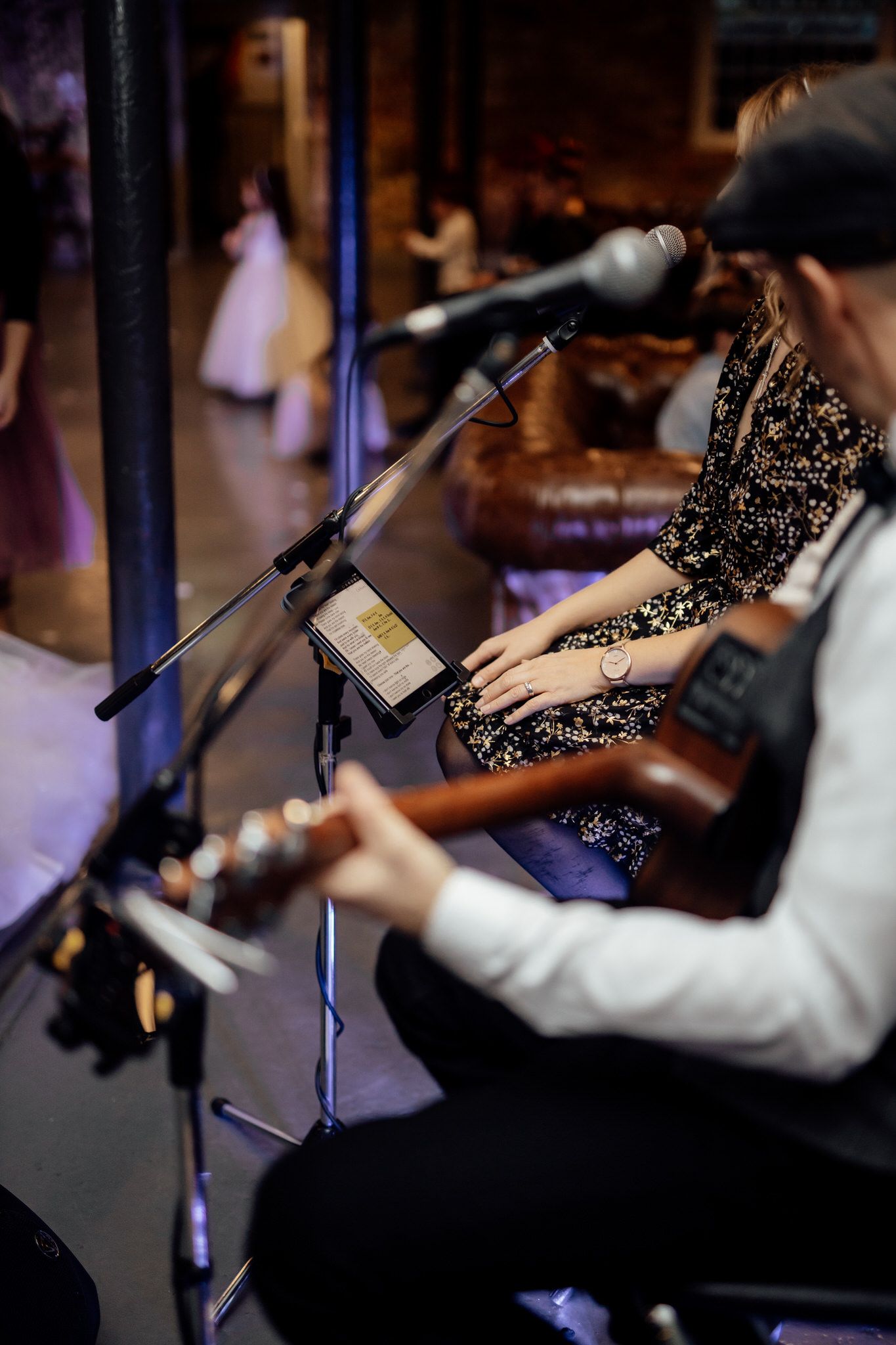 Musicians performing at wedding reception with instruments and microphones.