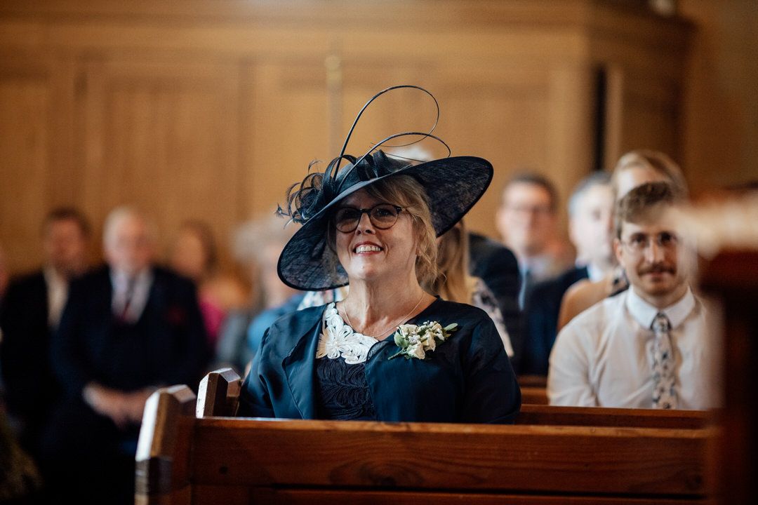 Wedding guests seated in church pews during traditional ceremony.