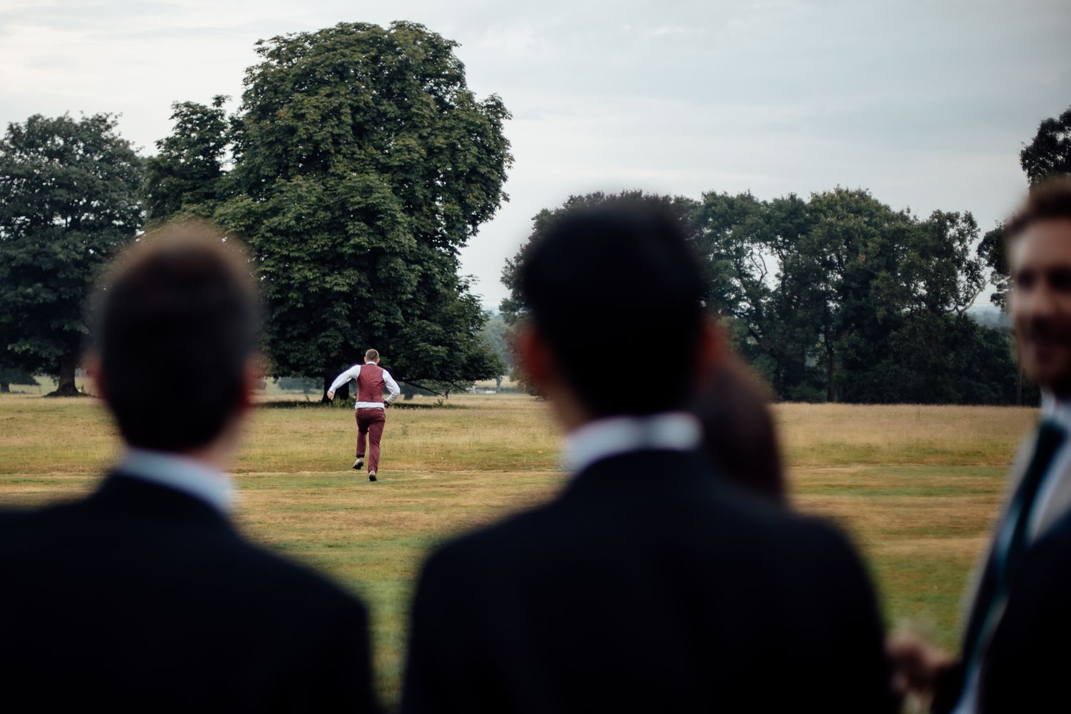 Wedding guests watching ceremony in an outdoor field setting.