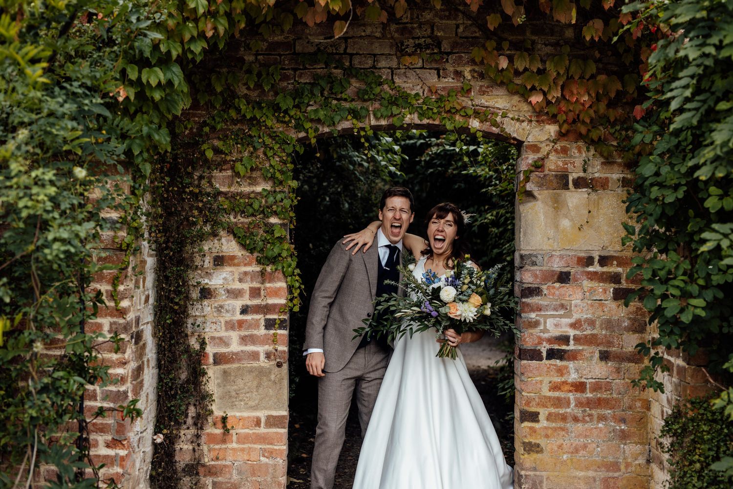 Rustic brick wall garden setting decorated for an outdoor wedding celebration.