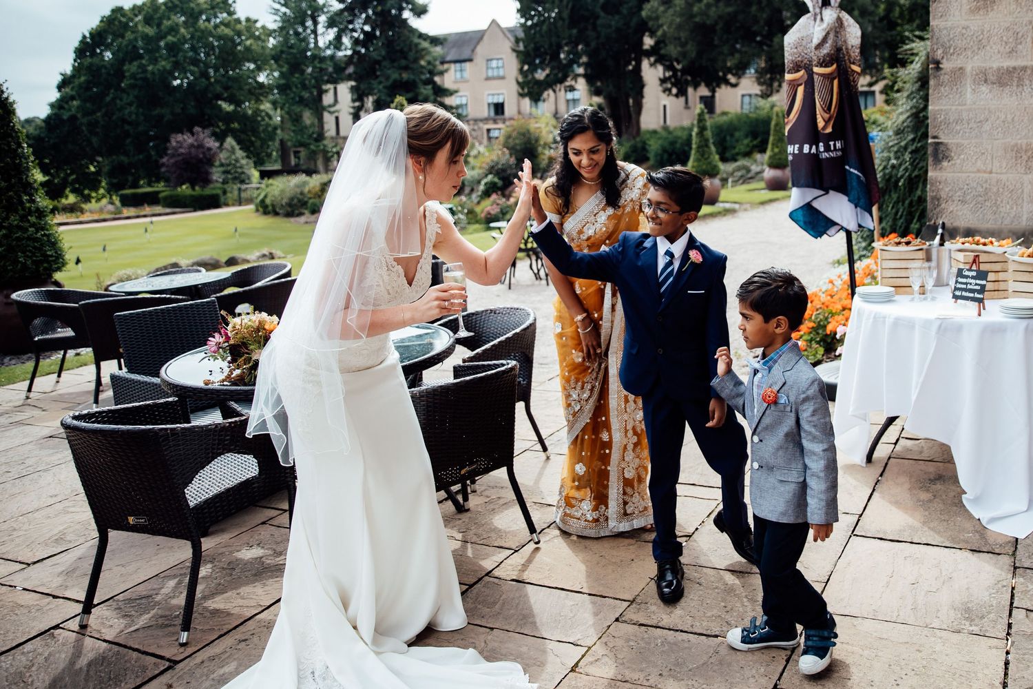 Wedding celebration on outdoor patio with guests gathering around bride.
